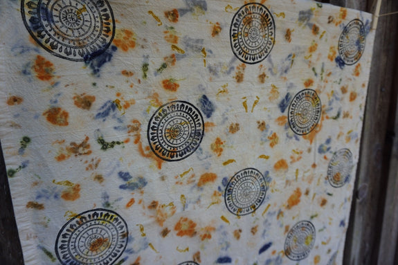 Floral patterned tea towel with circular designs on a wooden background